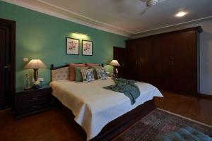 1 dormitorio con 1 cama grande y paredes verdes en Lohonostays Soni Estate, en Mussoorie