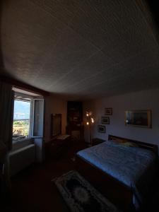 ein dunkles Schlafzimmer mit einem Bett und einem Fenster in der Unterkunft Nonna Anita in Castelveccana