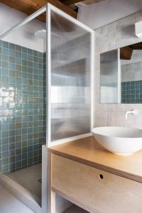 Un baño con lavabo y ducha de cristal. en House Na Chicca, en Bagnoregio