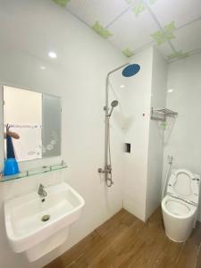 Baño blanco con lavabo y aseo en Hotel Việt Sang, en La Gi