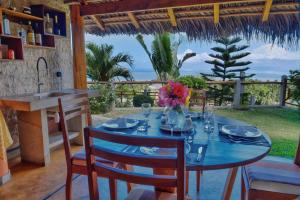 ein Esszimmer mit einem Tisch und Stühlen sowie Meerblick in der Unterkunft VILLA PANORAMA NOSY BE in Nosy Be