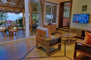 a living room with a chair and a table at VILLA PANORAMA NOSY BE in Nosy Be