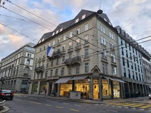 a large building on a city street with a store at Top City Center Apartments location next to Lion Monument in Lucerne