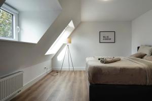 a white bedroom with a bed and a window at Appartment Weiden in Gronau