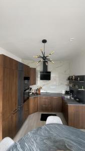 a kitchen with wooden cabinets and a ceiling fan at Le Charme Urbain Lumineux in Brussels