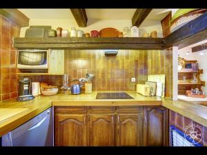 a kitchen with wooden cabinets and a sink and a microwave at CASA SANT BLAS de Alma de Nieve in Gessa +32 photos