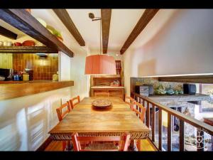 a dining room with a wooden table and a kitchen at CASA SANT BLAS de Alma de Nieve in Gessa