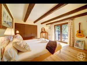a bedroom with a large bed with a guitar on the wall at CASA SANT BLAS de Alma de Nieve in Gessa