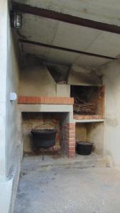 a brick fireplace with two black pots on it at LA CASA DEI RICORDI in Lanna