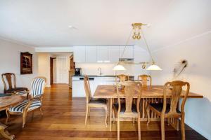 a kitchen and dining room with a wooden table and chairs at Le Bouveret - Ferienwohnungen Reinartz in Oberstaufen