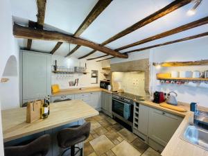 a kitchen with a wooden counter top in a room at Charming & Idyllic Grade 2 Listed Cottage for 6 Pass the Keys in Stony Middleton