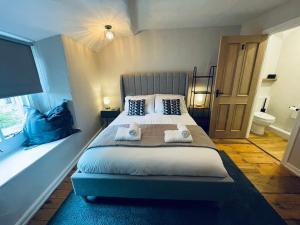 Stony MiddletonにあるCharming & Idyllic Grade 2 Listed Cottage for 6 Pass the Keysのベッドルーム1室(大型ベッド1台、タオル2枚付)