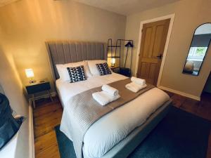 ein Schlafzimmer mit einem großen Bett mit zwei Handtüchern darauf in der Unterkunft Cosy Cottage for 6 & Pets Friendly in Hope Valley Pass the Keys in Stony Middleton