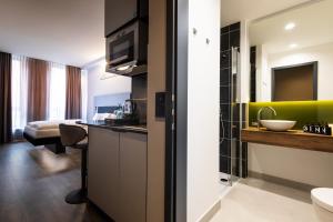 a hotel room with a bathroom with a sink at GINN Apartment-Hotel Stuttgart-Esslingen in Esslingen +51 photos