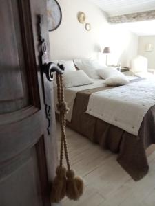 una camera con letto e lenzuola bianche di La maison perchee ad Aigues-Mortes