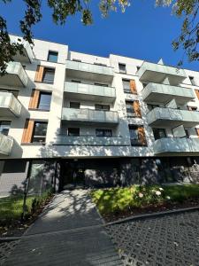 un edificio bianco con un passaggio pedonale di fronte di SkyTravel 27 Apartament Pileckiego Nowy Dwór Mazowiecki Airport Modlin 24H a Nowy Dwór Mazowiecki