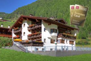 a large white building with flowers on the balconies at Pension Zur alten Mühle in Sölden