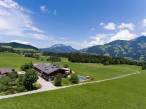 eine Luftansicht eines Hauses auf einem Feld mit Bergen in der Unterkunft Ferienhaus Weberhof in Hopfgarten im Brixental