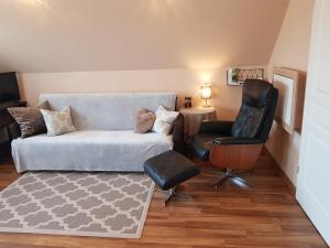 ein Wohnzimmer mit einem Sofa und einem Stuhl in der Unterkunft Apartamenty Nad Źródłem in Morawica