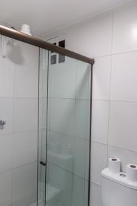 un bagno con doccia in vetro e carta igienica di Pousada La Bella Luna a Porto De Galinhas