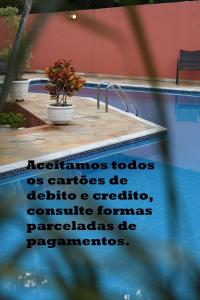 - un panneau à côté de la piscine dans l'établissement Pousada Casa Doce Vida, à Águas de Lindóia