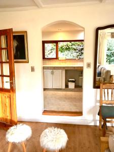 Sala de estar con 2 taburetes blancos y espejo en Casita excelente ubicación en San Carlos de Bariloche