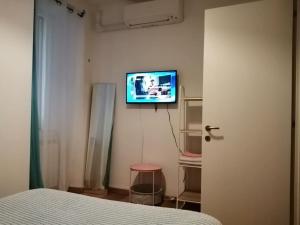 a bedroom with a bed and a tv on the wall at lucia haus trieste in Trieste