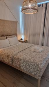 a bedroom with a bed and a chandelier at Suite paradise - E013 garden apartment in Caesarea