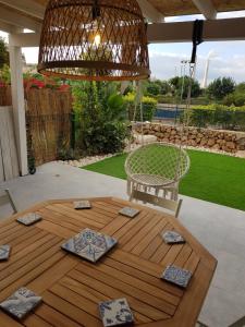 a porch with a swinging chair and a table at Suite paradise - E013 garden apartment in Caesarea