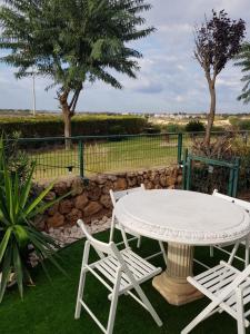 a table and two chairs and a table and two trees at Suite paradise - E013 garden apartment in Caesarea +13 photos