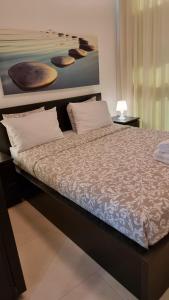 1 cama en un dormitorio con una pintura en la pared en Suite Paradise - D111, en Cesarea