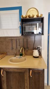 a kitchen counter with a sink and a microwave at Suite Paradise - D111 in Caesarea