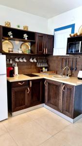 una cocina con armarios de madera y fregadero en Suite Paradise - D111 en Caesarea