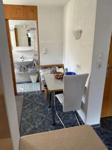 Zimmer mit einem Tisch und einem Bad mit einem Waschbecken in der Unterkunft Haus Ritter 286 in Schoppernau