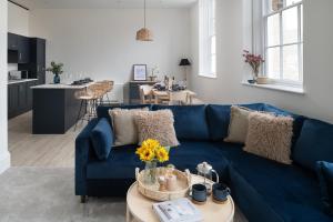 a living room with a blue couch and a table at Apartment 5 Y Capel, Zip-link beds, Free on site parking, very close to town centre amenities and A55 expressway in St Asaph