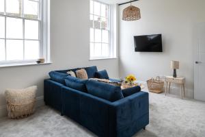 un sofá azul en la sala de estar con TV en Apartment 5 Y Capel, Zip-link beds, Free on site parking, very close to town centre amenities and A55 expressway, en St Asaph