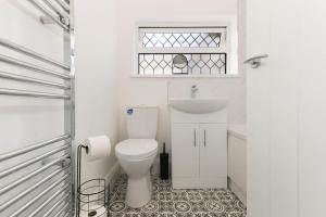 a white bathroom with a toilet and a sink at Modern home near Alexandra Dock in Great Coates