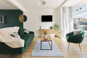 a living room with a green couch and a table at Modern home near Alexandra Dock in Great Coates