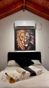 a bed with a painting of a lion on the wall at בקתת גליתה in Yuval
