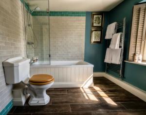 a bathroom with a toilet and a bath tub at George and Dragon Clifton in Penrith