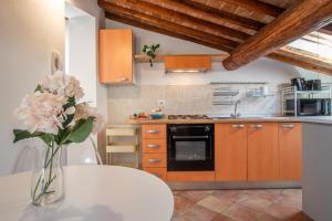 a kitchen with a vase of flowers on a table at Colours Studio 10 m away Piazza del Campo in Siena +20 photos