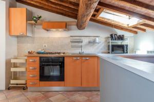 a kitchen with orange cabinets and a black oven at Colours Studio 10 m away Piazza del Campo in Siena