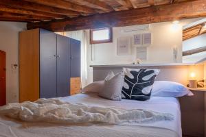 a bedroom with a white bed with pillows at Colours Studio 10 m away Piazza del Campo in Siena