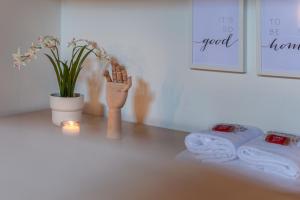a bathroom with towels and a candle and a plant at Colours Studio 10 m away Piazza del Campo in Siena