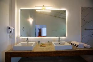 a bathroom with two sinks and a large mirror at Sri Lanka Beach House Hotel and SPA in Hikkaduwa