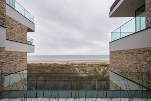 een uitzicht op het strand vanuit een gebouw bij Modern en gezellig appartement vlak aan het strand in Blankenberge