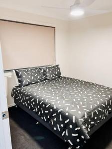Una cama en blanco y negro en una habitación en Stay at Chi’s en Kingston