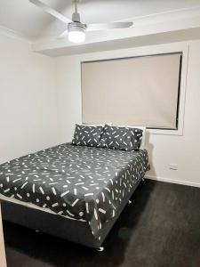 a bed in a room with a ceiling fan at Stay at Chi’s in Kingston