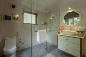Un baño con inodoro, lavabo y ducha. en LohonoStays Ivy Cottage, en Dehradun 20 fotos más