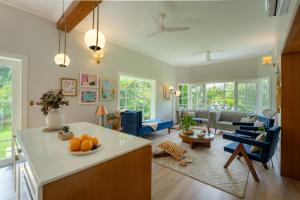 Una cocina y una sala de estar con un sofá y una mesa. en LohonoStays Ivy Cottage, en Dehradun